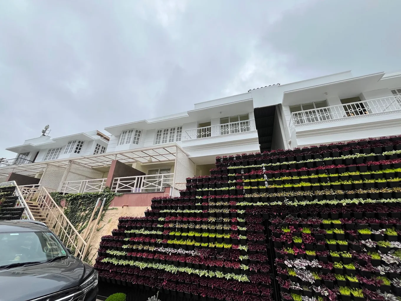 Front view of Delightz Inn, Ooty cottages with valley backdrop