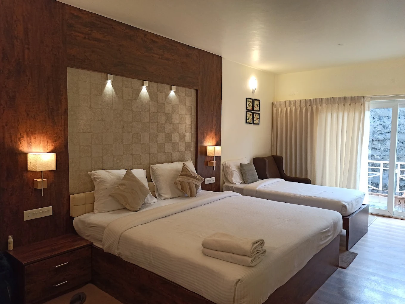 Room interior with TV and seating at Delightz Inn, Ooty