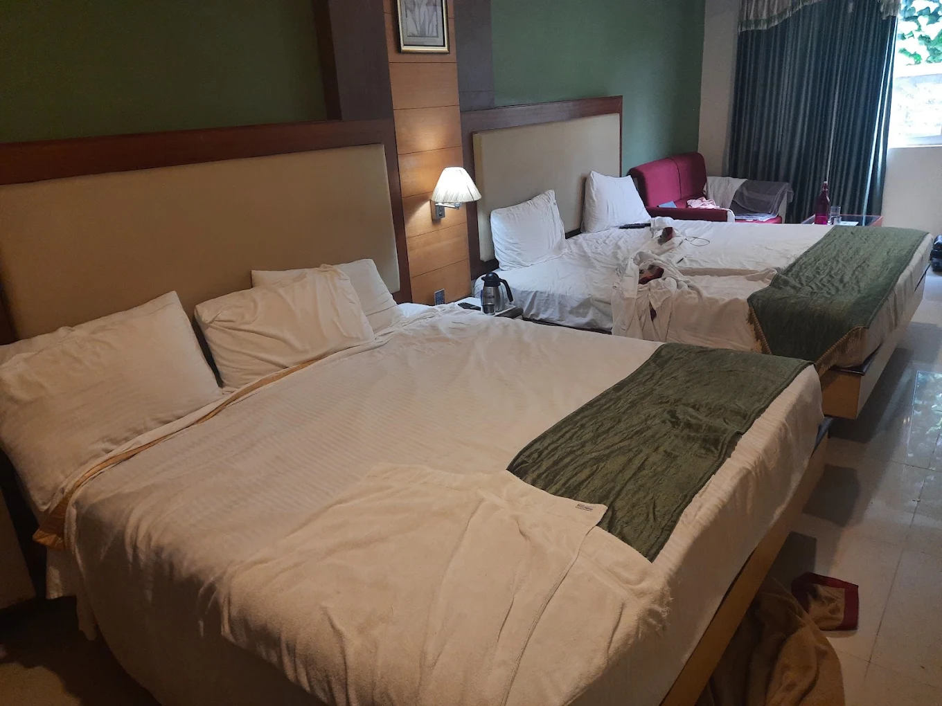 Bed and TV unit inside room at Ponmari Residencyy Ooty