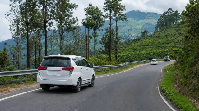 Private tourist cab travelling on a winding Nilgiris road towards Ooty